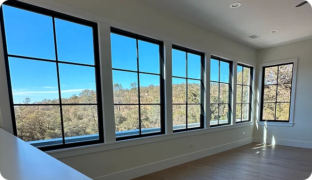 Modern home interior with large black-framed windows and abundant natural light