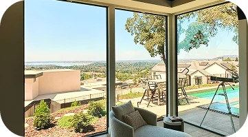 Luxury home interior with panoramic floor-to-ceiling windows and outdoor view