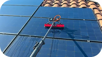 Professional solar panel cleaning on residential rooftop using specialized equipment